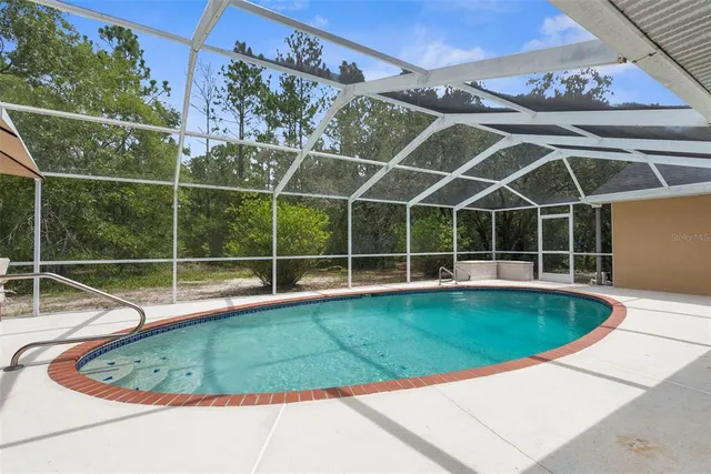 an aerial view of a house with a yard and large trees