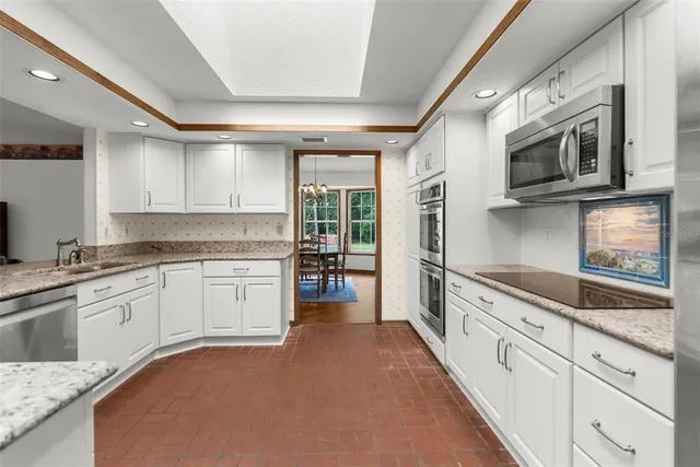 a kitchen with granite countertop a sink and a microwave