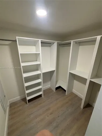 a view of walk in closet with empty racks