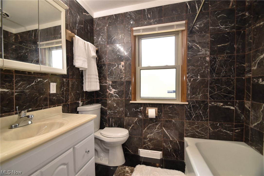 3681 Brinkmore Road Cleveland Heights, OH 44121 - Photo 17 of 27 Full bathroom with bathing tub / shower combination, plenty of natural light, tile walls, and large vanity