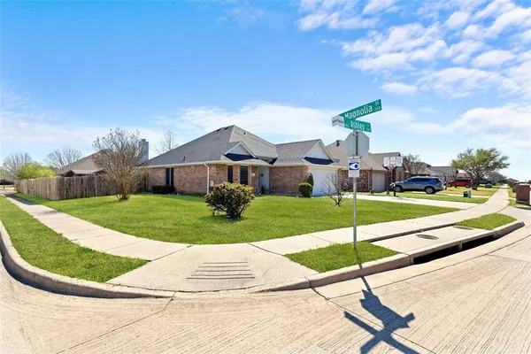 a view of a house with a big yard plants and large tree