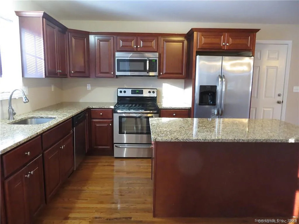 4 Grove Street Moodus, CT 06469 - Photo 11 of 11 a kitchen with stainless steel appliances granite countertop a stove a sink dishwasher and a refrigerator