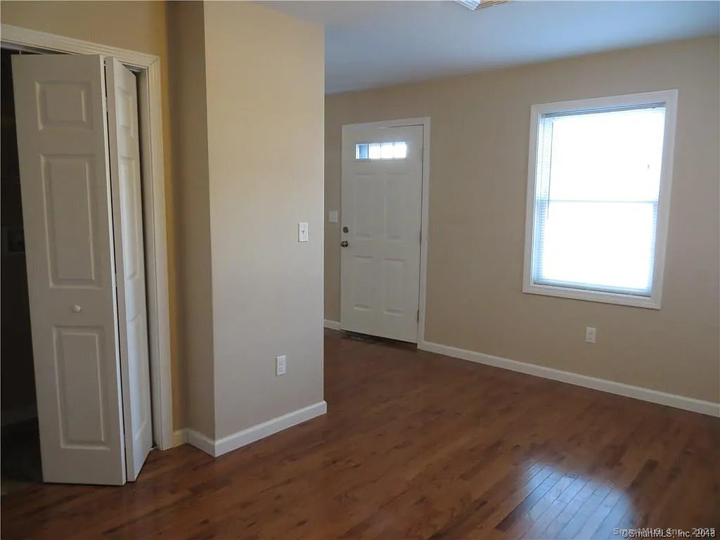 4 Grove Street Moodus, CT 06469 - Photo 7 of 11 an empty room with wooden floor closet and windows