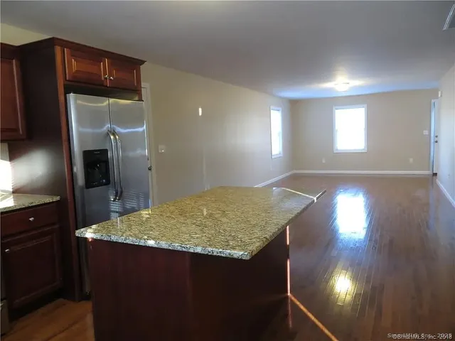 a kitchen with kitchen island a refrigerator sink and stove