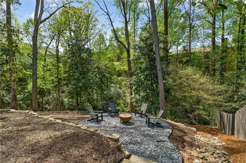 a view of a chairs and table in the backyard