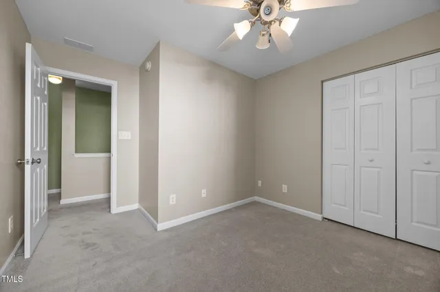 an empty room with fan and entrance