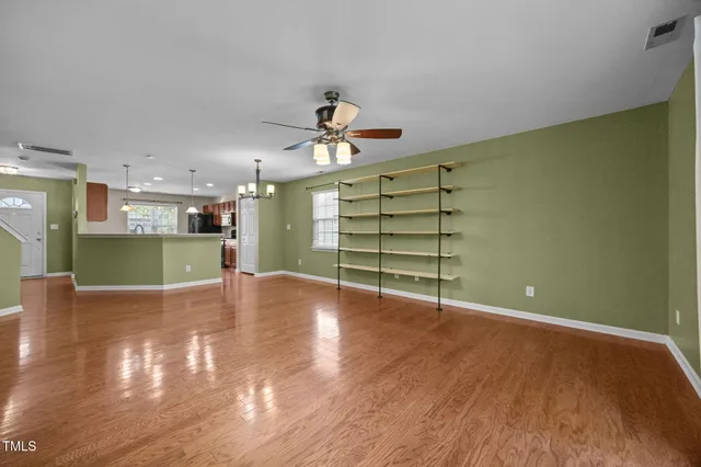 a view of a room with a wooden floor and a ceiling fan