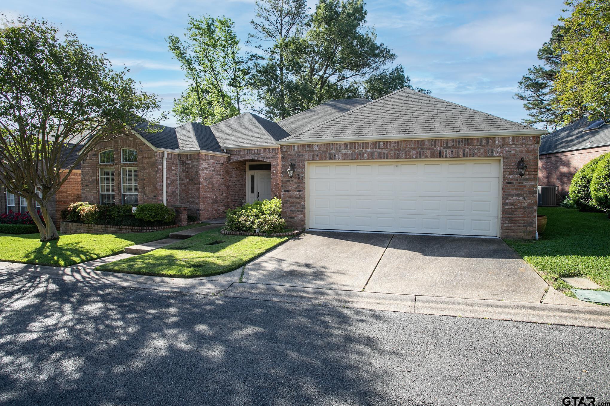 1418 Hollytree Place Tyler, TX 75703 - Photo 2 of 46 a front view of a house with a yard and garage
