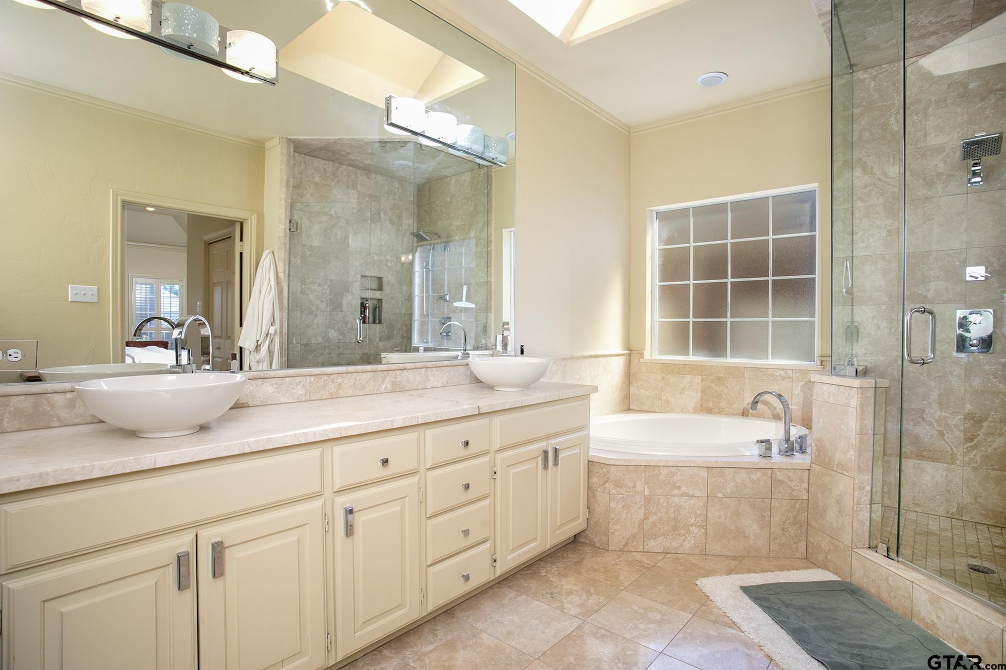 1418 Hollytree Place Tyler, TX 75703 - Photo 24 of 46 a bathroom with a tub a sink double vanity and a mirror
