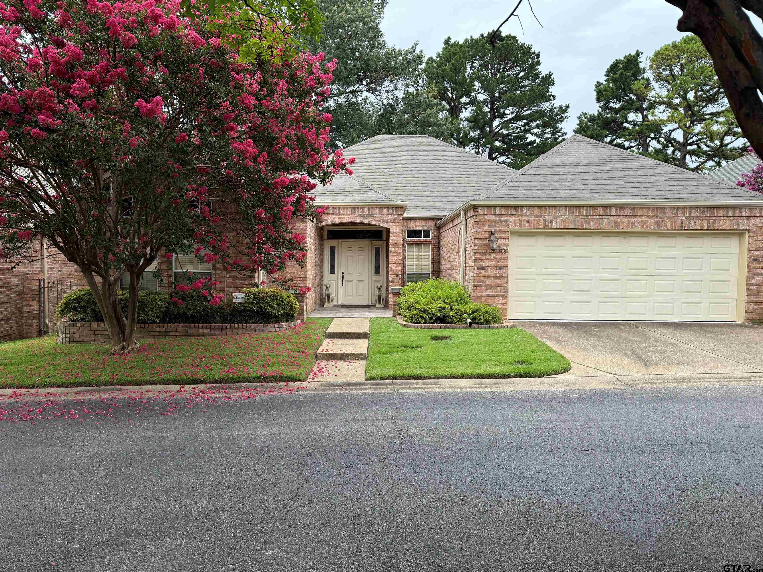 1418 Hollytree Place Tyler, TX 75703 - Photo 3 of 46 a front view of a house with a yard and garage