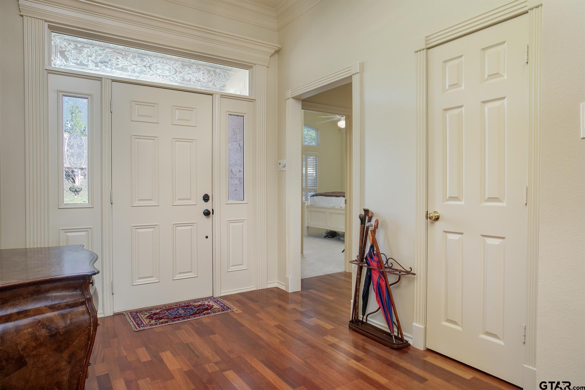 1418 Hollytree Place Tyler, TX 75703 - Photo 4 of 46 a bedroom with a bed and a chandelier