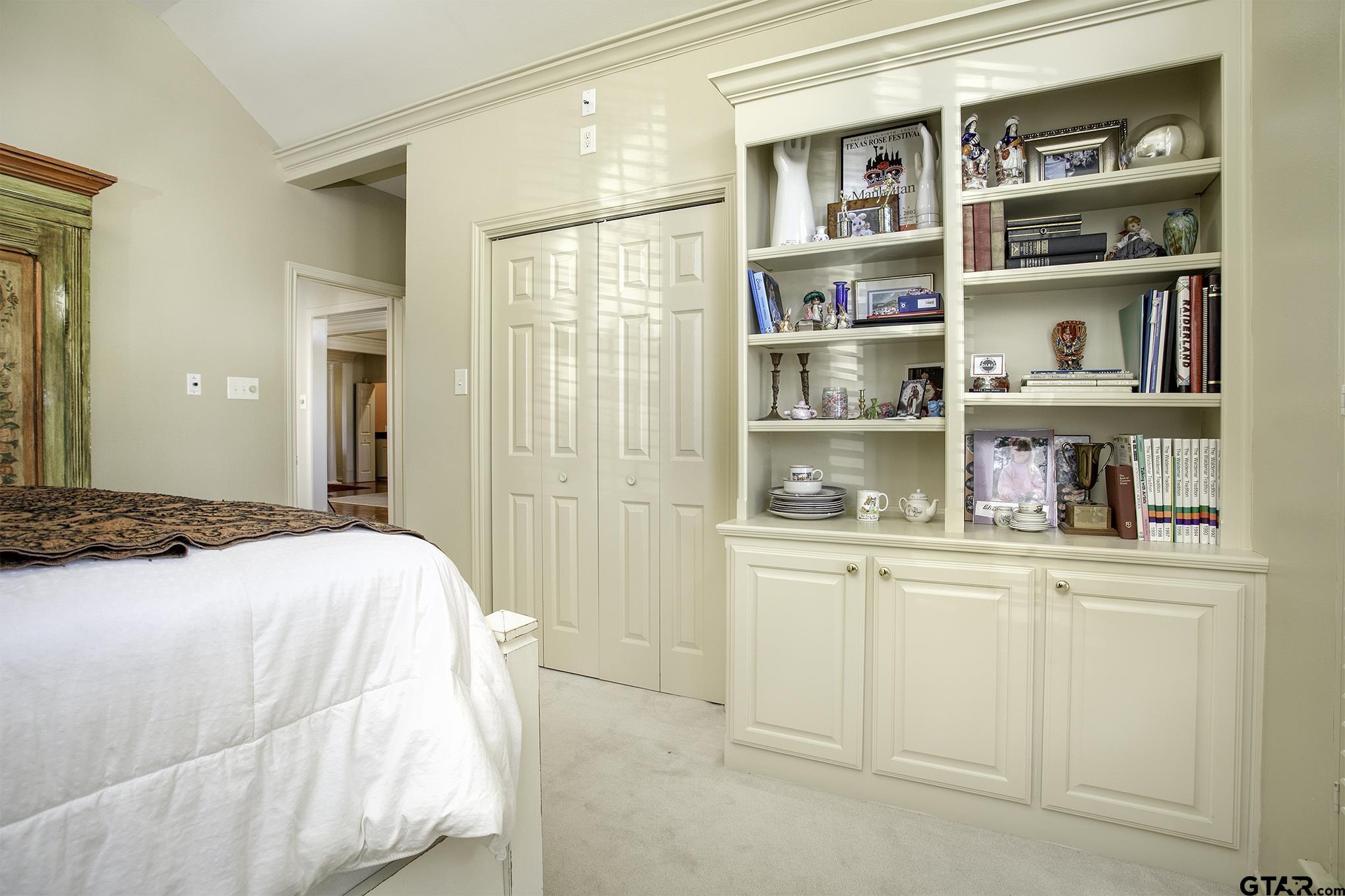 1418 Hollytree Place Tyler, TX 75703 - Photo 5 of 46 a bedroom with a bed and a book shelf
