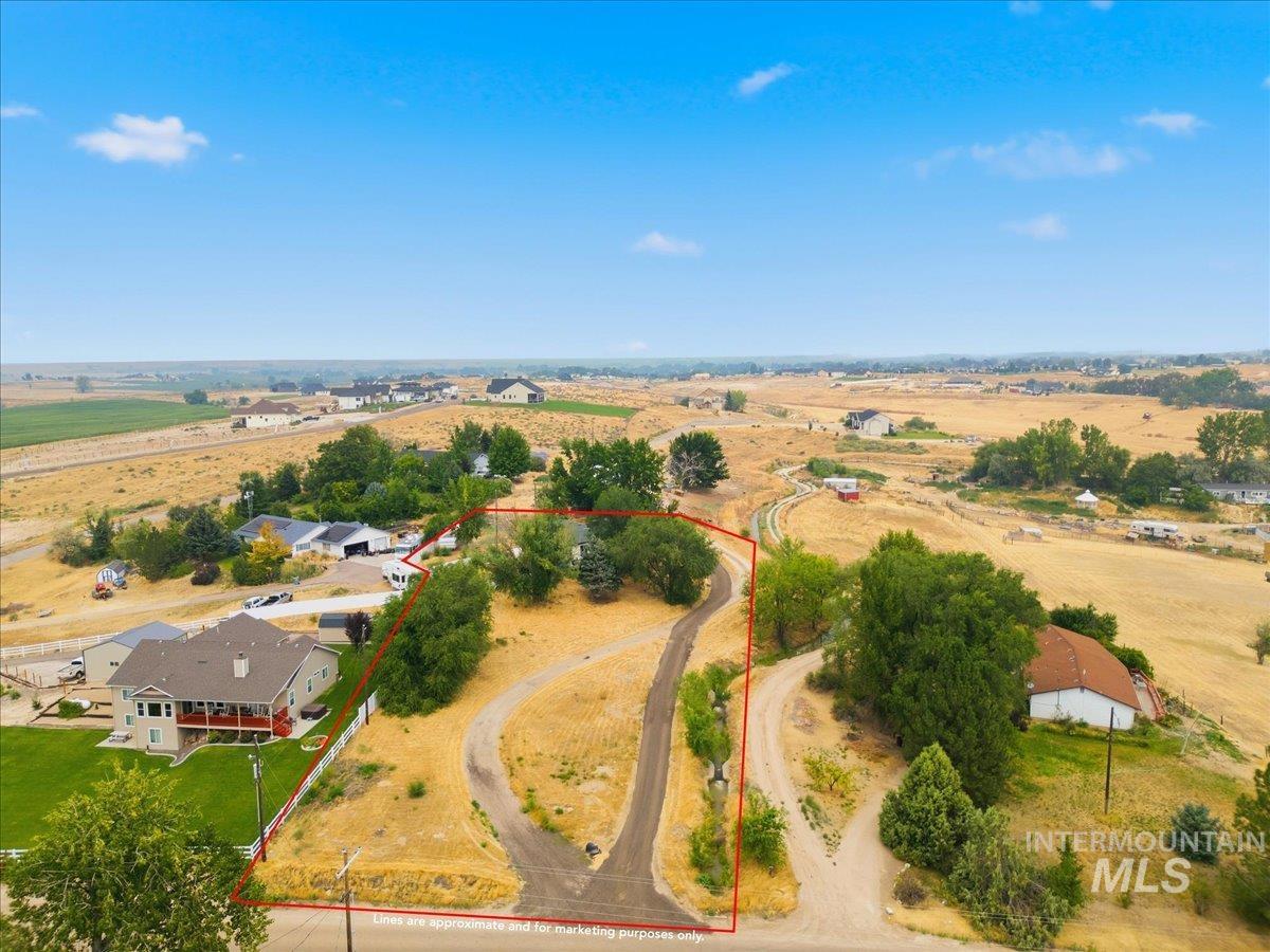 17114 Goodson Road Caldwell, ID 83607 - Photo 41 of 47 Expansive property parcel featuring a paved driveway, natural landscaping, and mature trees