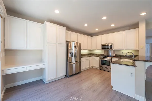 a kitchen with a refrigerator cabinets and wooden floor