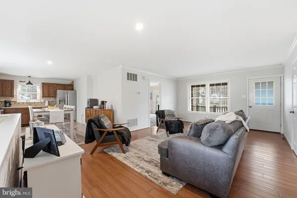 a dining room with stainless steel appliances a refrigerator and a dining table with wooden floor
