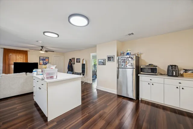 a kitchen with a dining table chairs refrigerator and cabinets