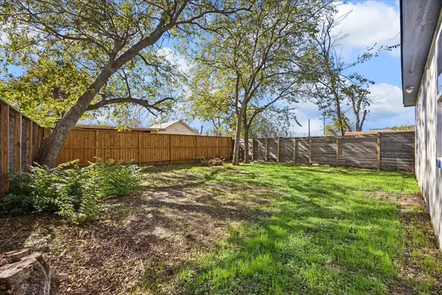 a view of backyard with wooden fence