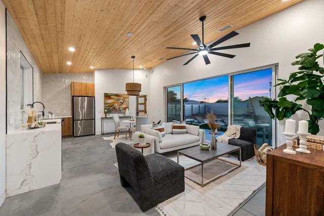 a living room with furniture a chandelier and a dining table