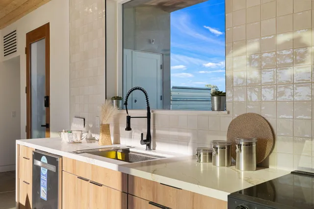 a kitchen with a sink and a large mirror