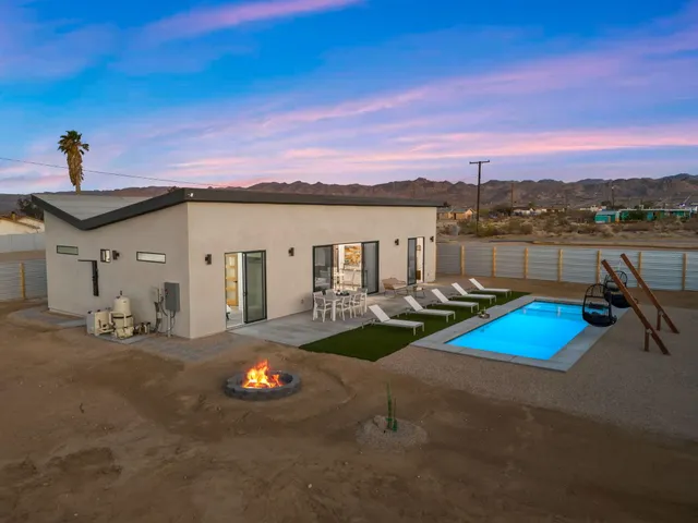 a view of a house with pool and chairs