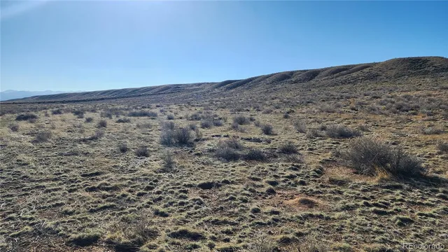 a view of a dry yard with mountain and mountain view