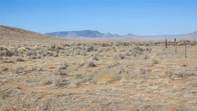 a view of a dry yard with mountains in the background