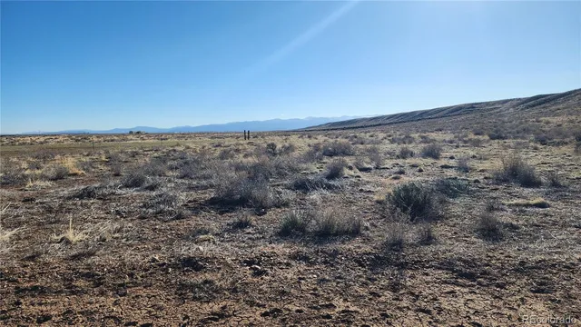an aerial view of house with yard and mountain view in back