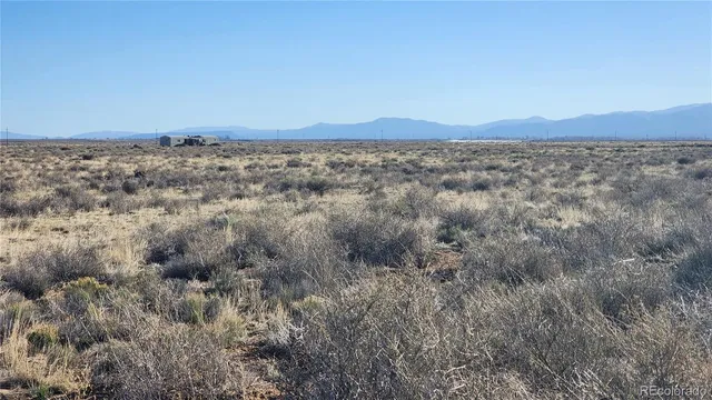 a view of a field with a mountain in the background