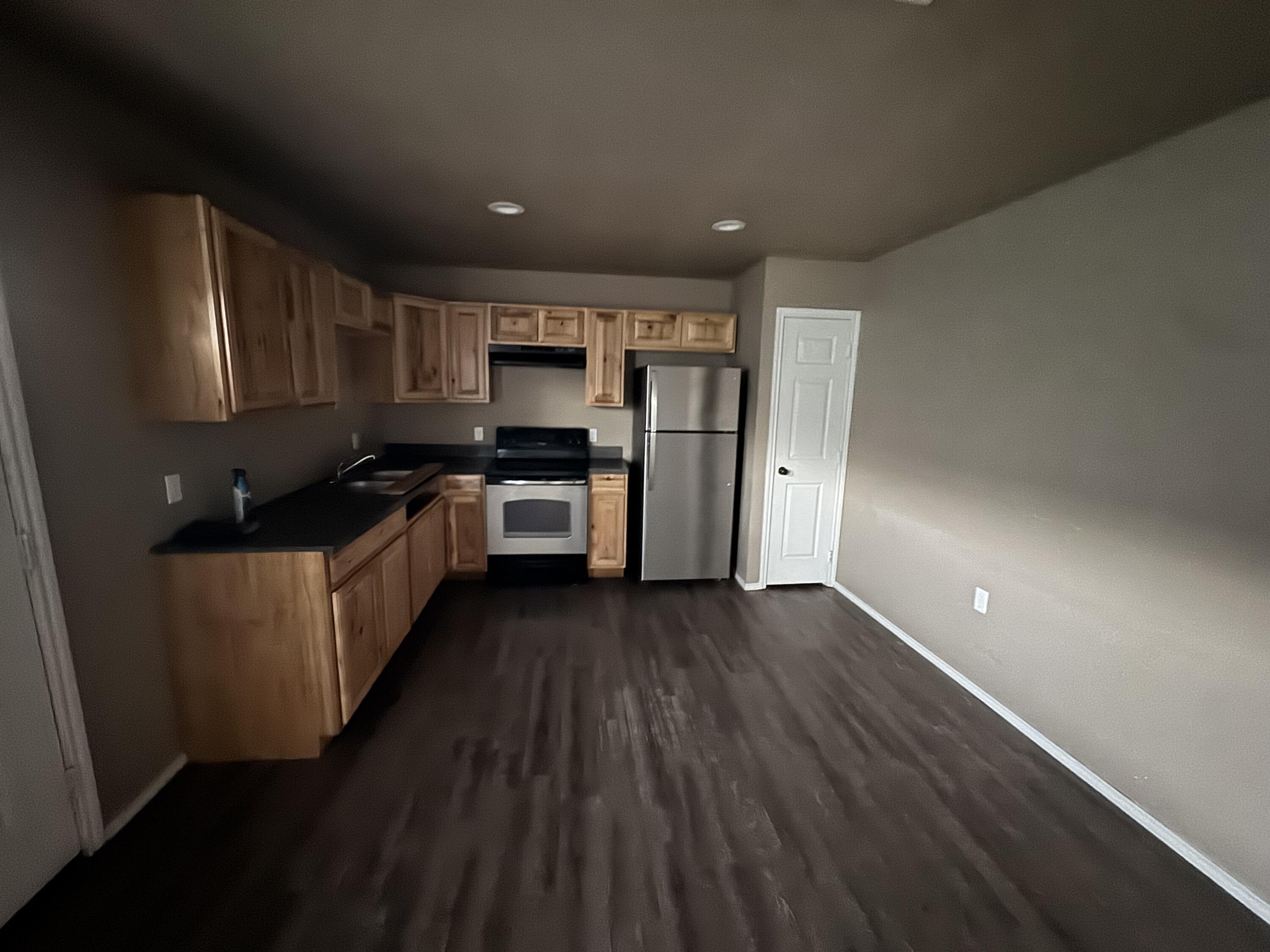 a kitchen with stainless steel appliances a refrigerator and a stove top oven