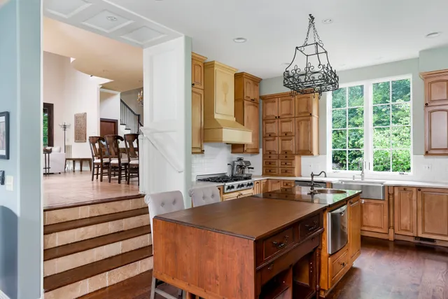 a kitchen with a center island wooden floor and a chandelier