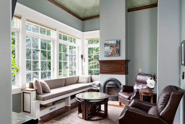 a living room with furniture a fireplace and a large window