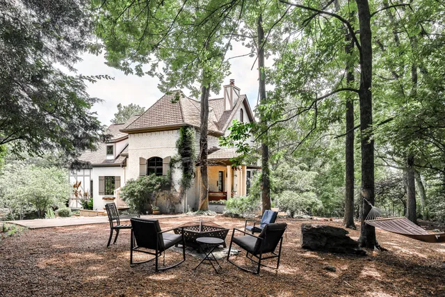 a view of a house with backyard and sitting area