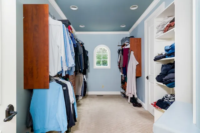 a view of walk in closet with clothes and shoes