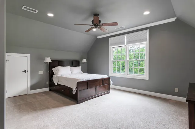 a spacious bedroom with a bed and a chandelier