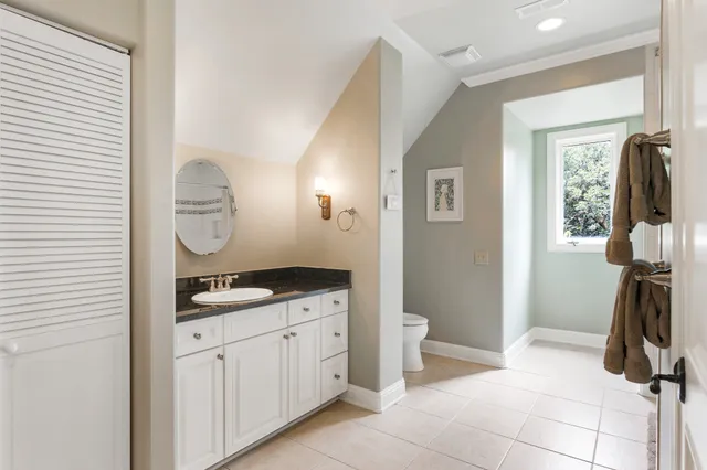 a bathroom with a granite countertop sink a toilet and a mirror
