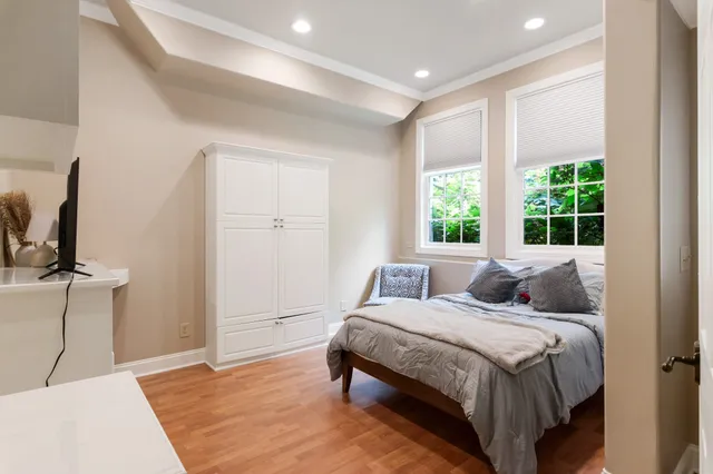 a bedroom with a bed a mirror and a large window