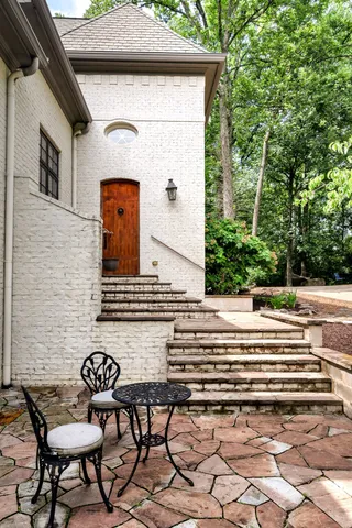 a view of backyard with a table and chairs and potted plants