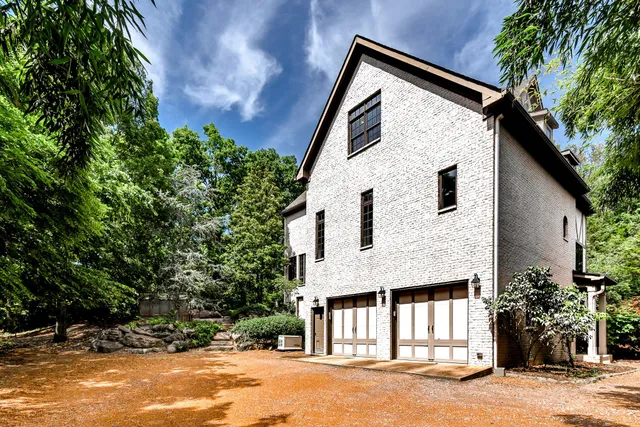 a view of a white house with a yard and large tree