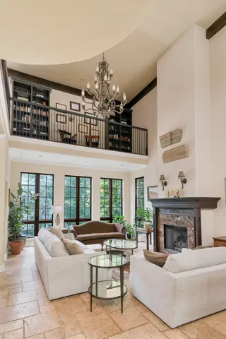 a living room with furniture a chandelier and a fireplace