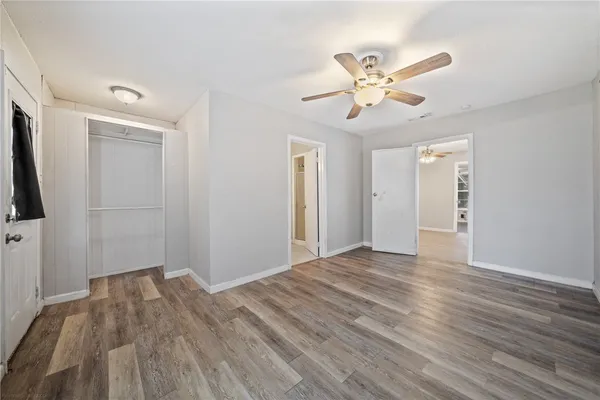 a view of empty room with wooden floor and ceiling fan