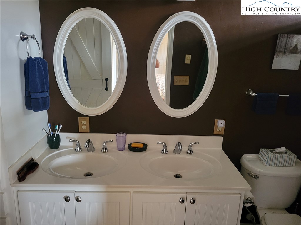 1729 Cranberry Creek Road Laurel Springs, NC 28644 - Photo 7 of 26 a bathroom with a toilet sink and mirror