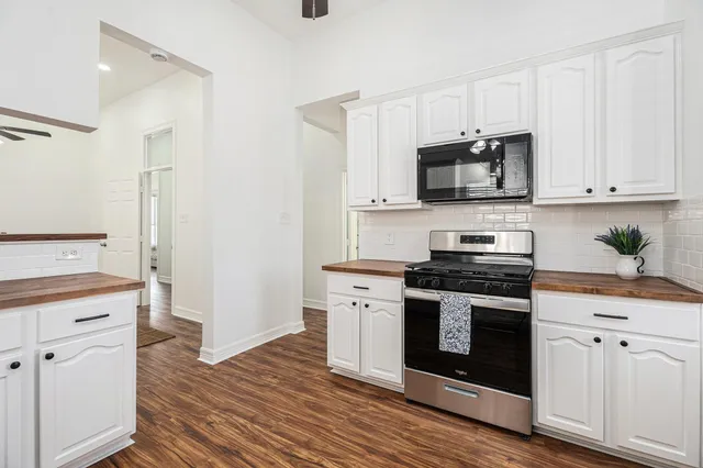 a kitchen with white cabinets and stainless steel appliances