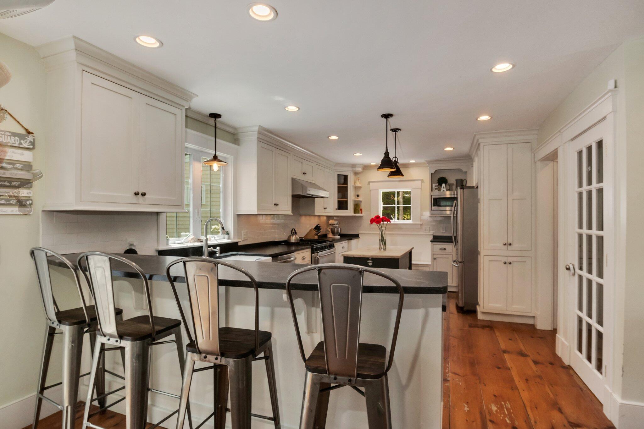 2 Palmer Road East Sandwich, MA 02537 - Photo 13 of 74 a kitchen with stainless steel appliances kitchen island granite countertop a table chairs refrigerator and microwave
