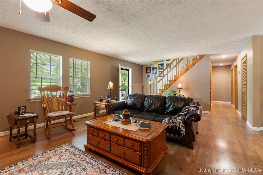 10440 East Saylor Road Salem, IN 47167 - Photo 23 of 57 Pic of living room with stairs leading to upper level and hallway to right leading to primary suite and 1st floor laundry!