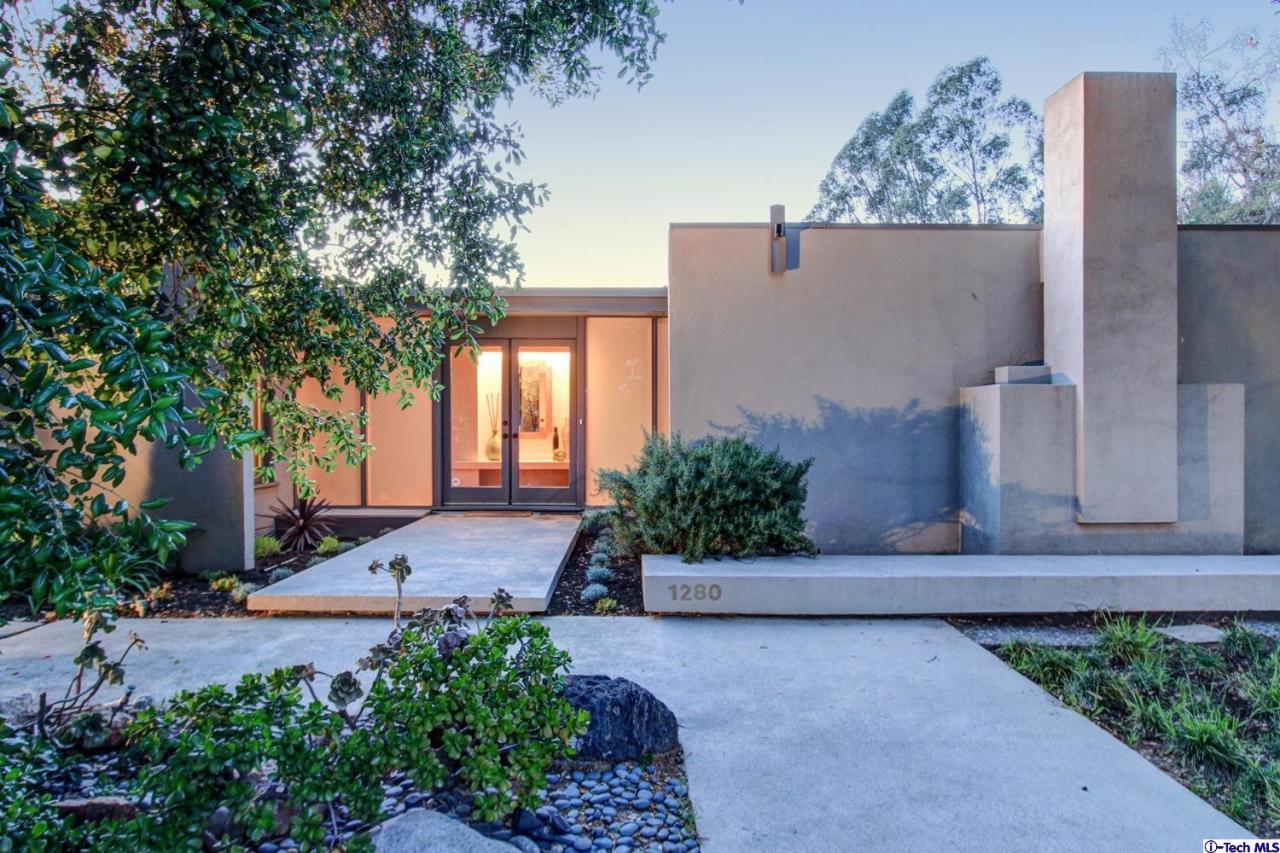 a view of a street with potted plants and large trees
