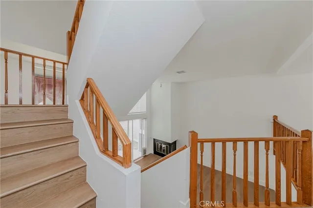 a view of staircase with lots of frames on wall and a window