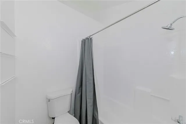 a white toilet sitting next to a shower curtain