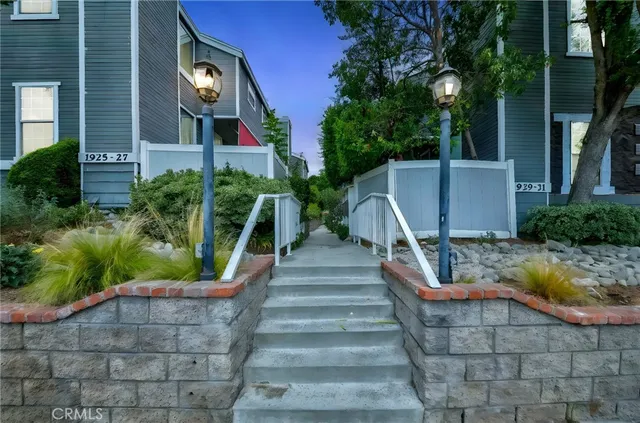 a front view of a house with a yard and potted plants