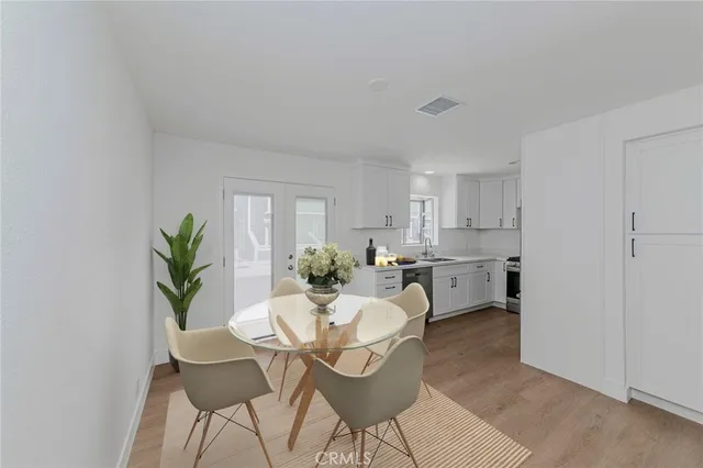 a living room with furniture a potted plant and open kitchen view