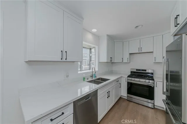 a kitchen with granite countertop white cabinets and stainless steel appliances